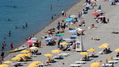 Antalya'da sıcaktan bunalan yerli ve yabancı turistler, dünyaca ünlü Konyaaltı