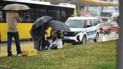 Kastamonu'da yağmur altında yaralanan motosiklet sürücüsüne trafik polisi şemsiyeyle yardım