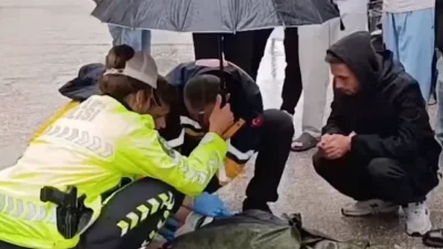 Bursa İnegöl'de bir trafik kazasında, yağmur altında yaralı gencin başında